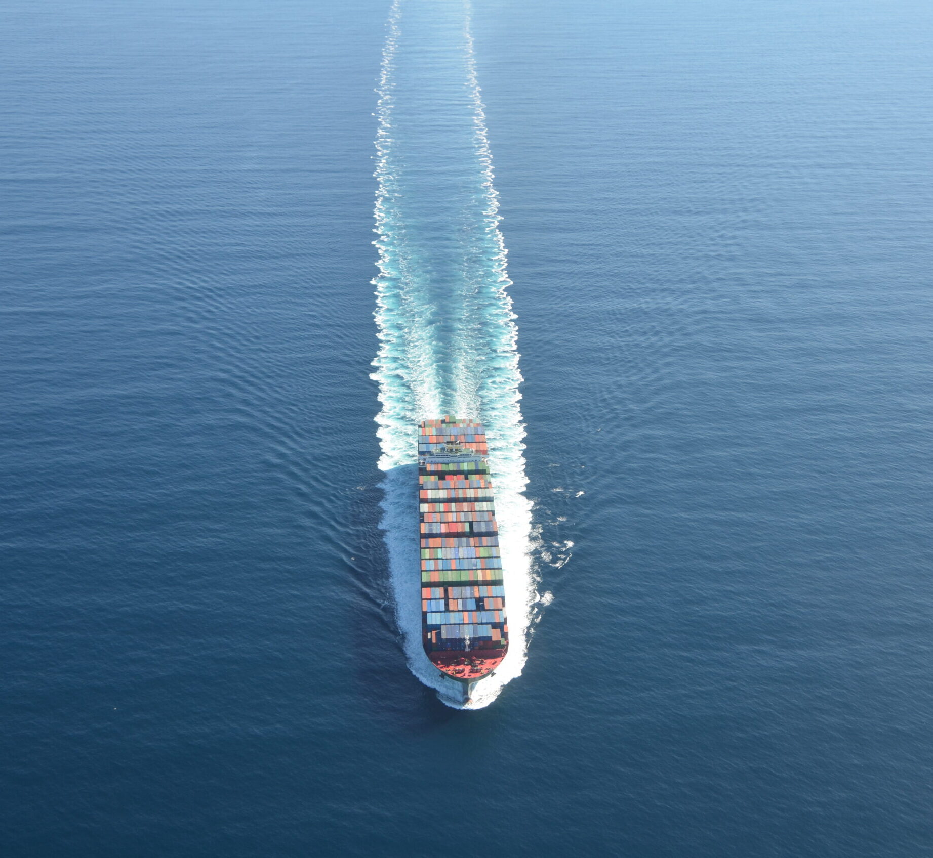 Large cargo ship sails toward the out edge of the photo frame.
