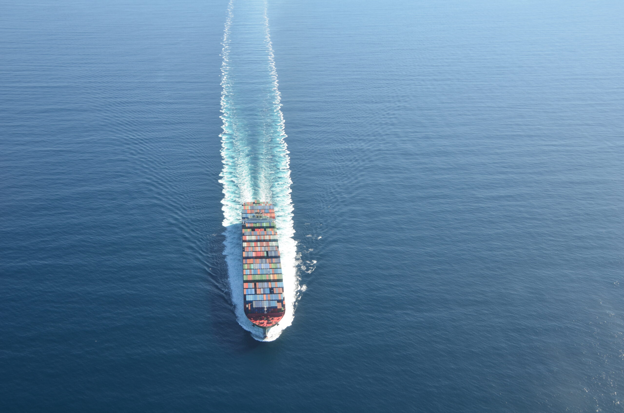 Large cargo ship sails toward the out edge of the photo frame.