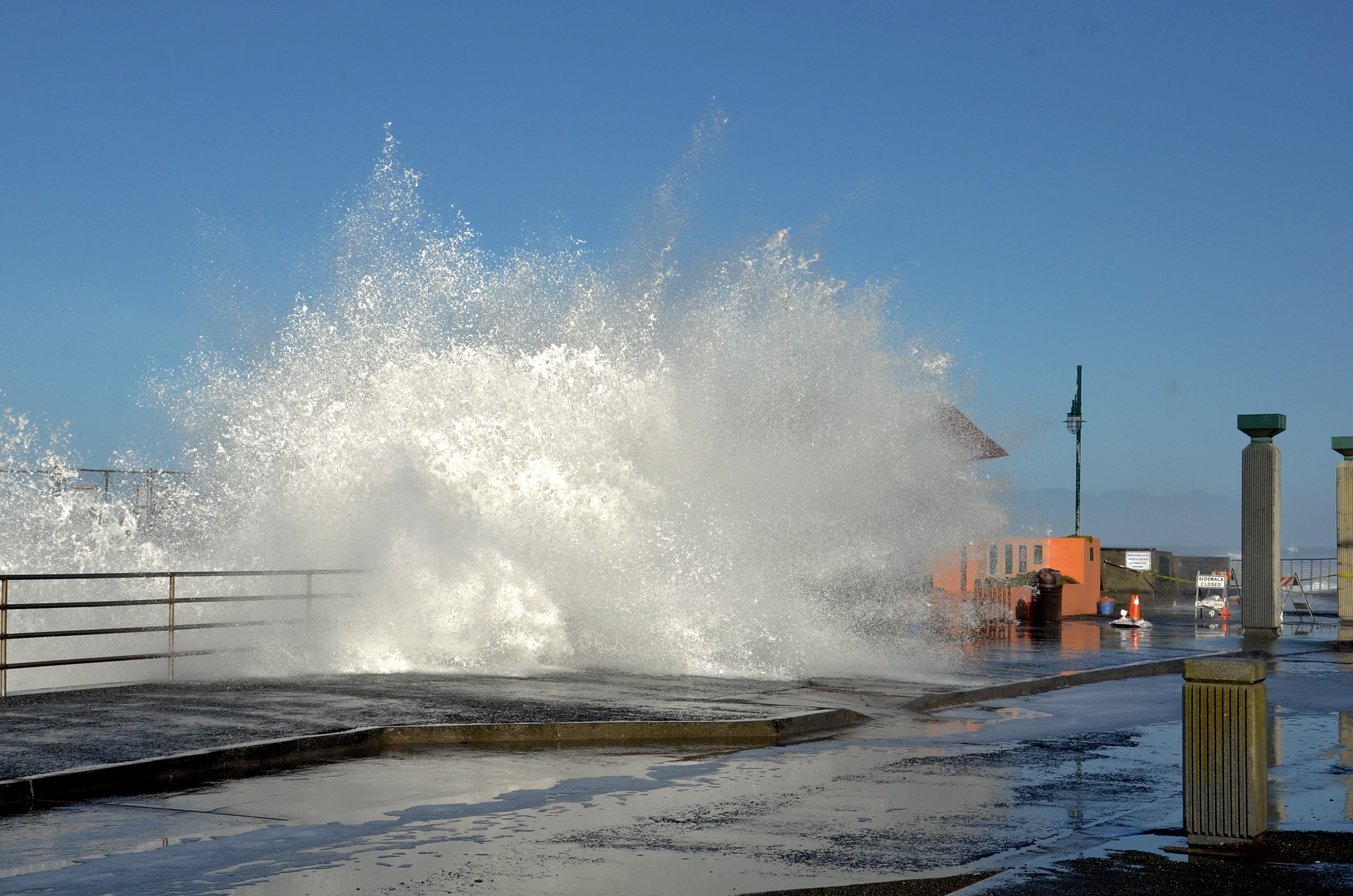 Image of large wave exploding onto pier.